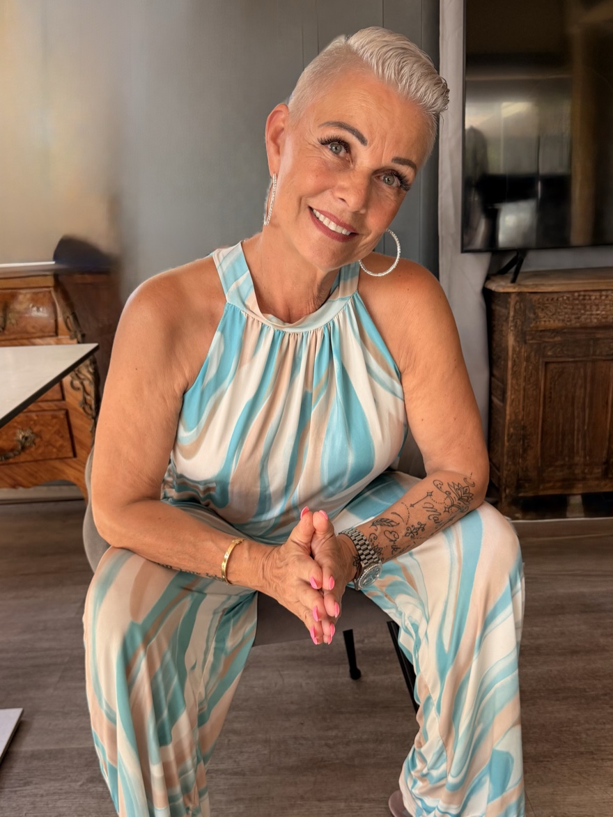 Renée Gorgoglione mira con calma y de frente a la cámara, con las manos entrelazadas delante de ella.